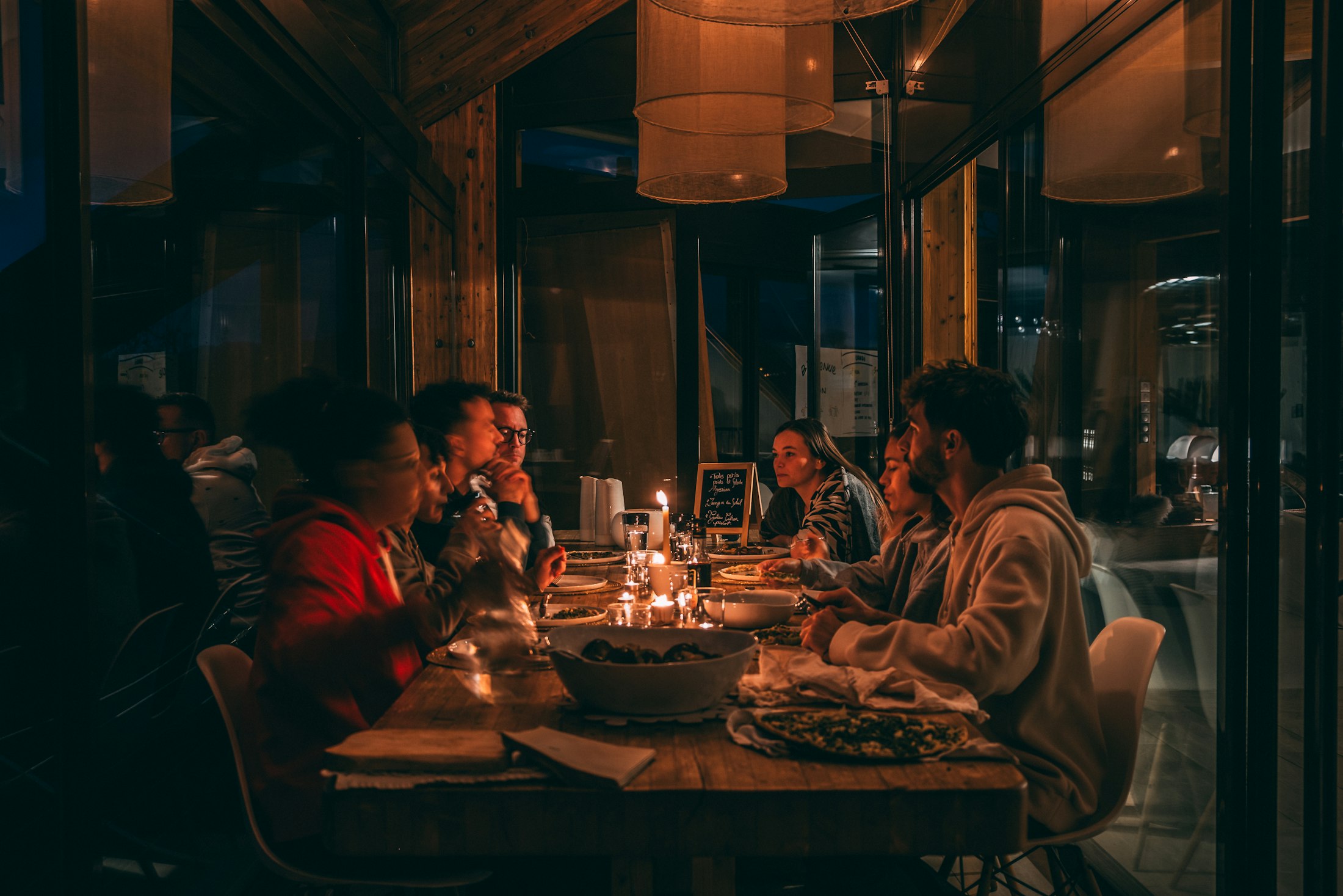 Friends gathered around a candlelit table in a warmly lit room